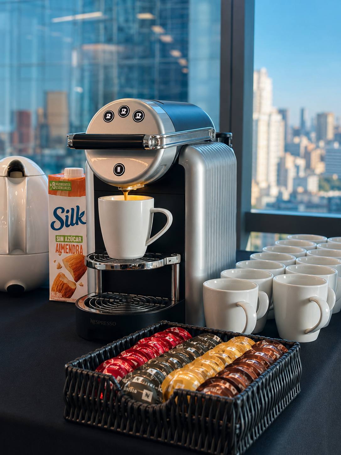 Estación de coffee break con café, jugos y medialunas en una oficina