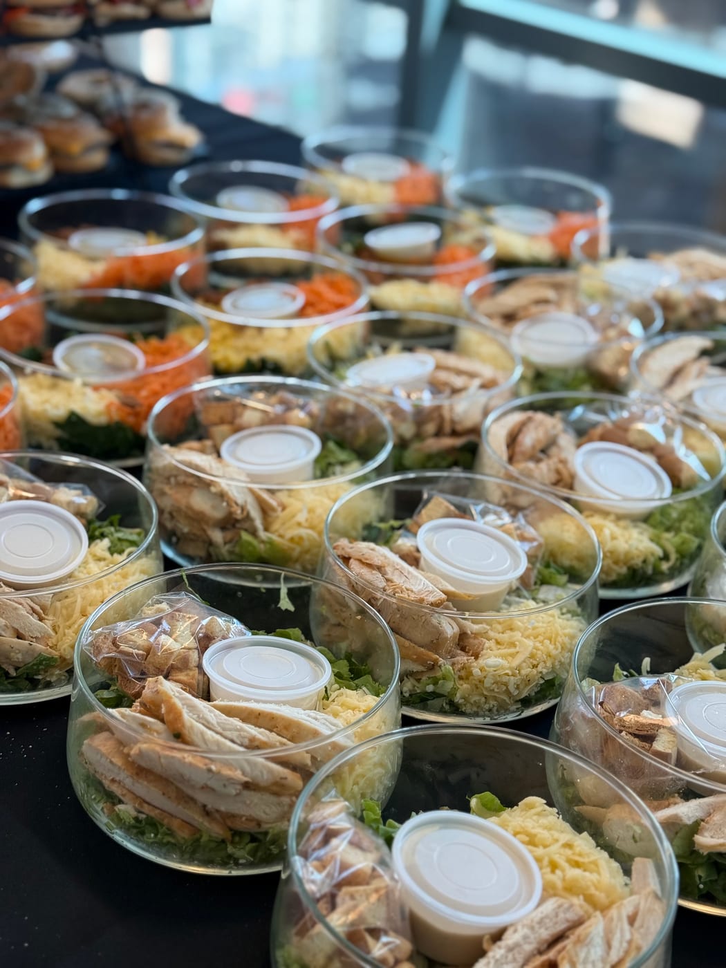 Vasos individuales de ensalada César con pollo para un almuerzo corporativo
