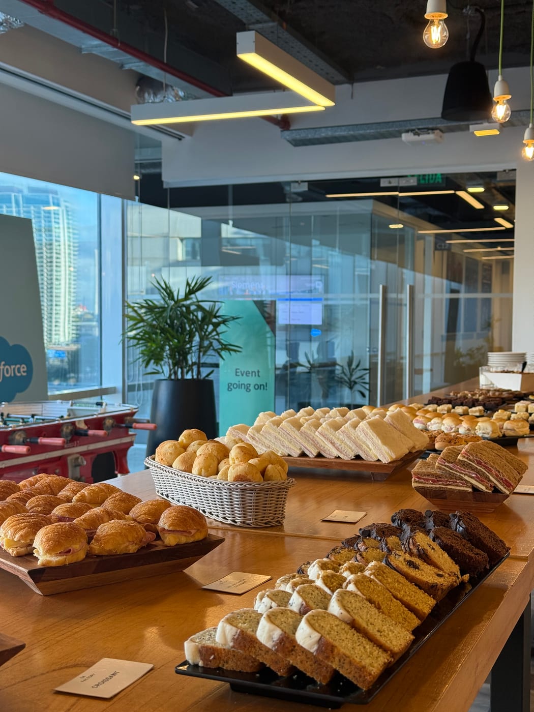 Mesa de coffee break con budines, medialunas y facturas surtidas en bandejas