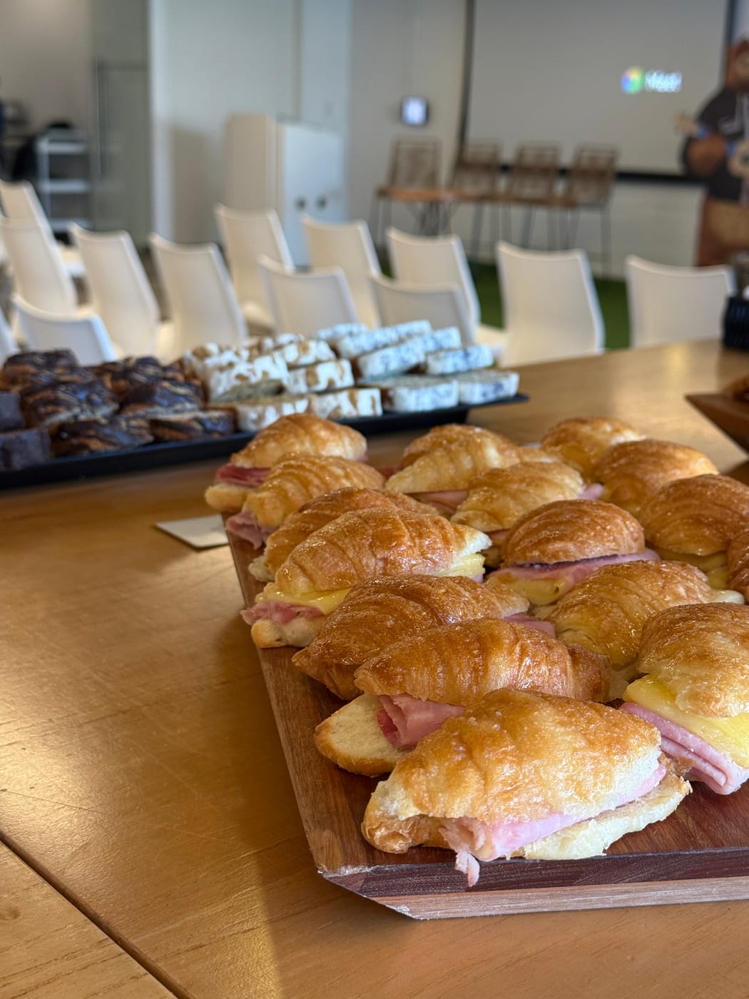 Primer plano de croissants de jamon y queso servidos en tabla de madera