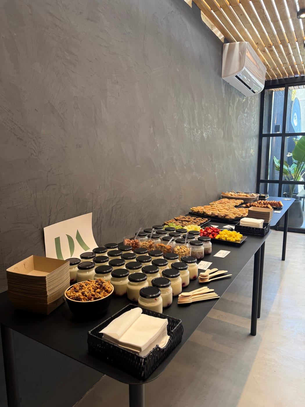Estacion de coffee break con granolas, frutos secos y postres en vasos individuales
