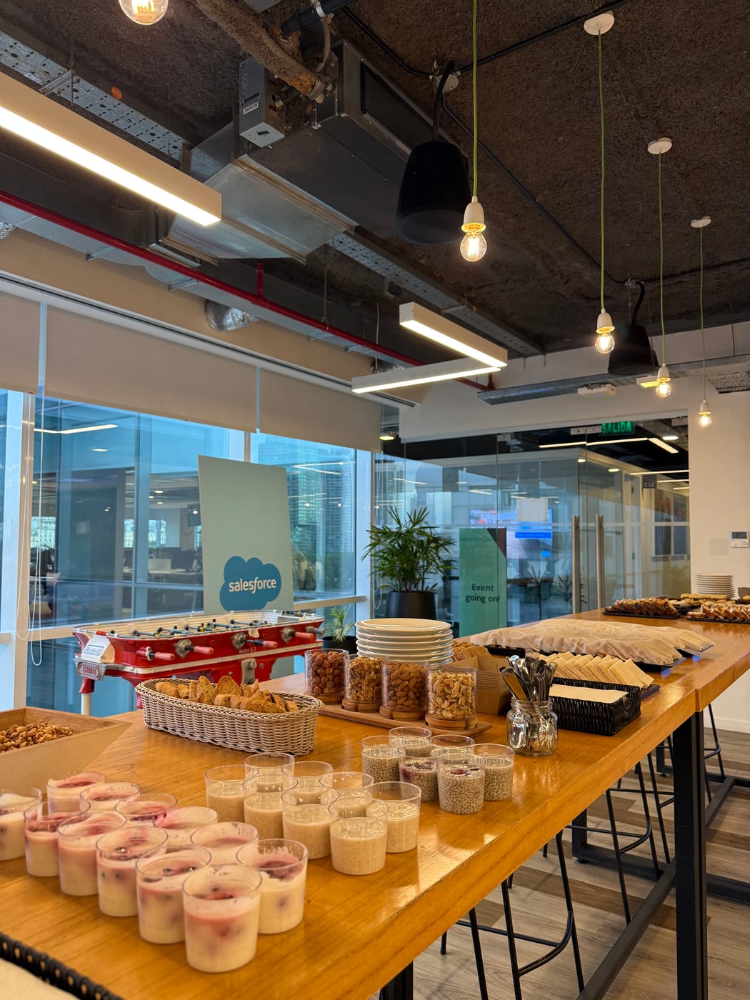 Mesa de desayuno con granolas, frutos secos y vasitos de yogur para un evento corporativo