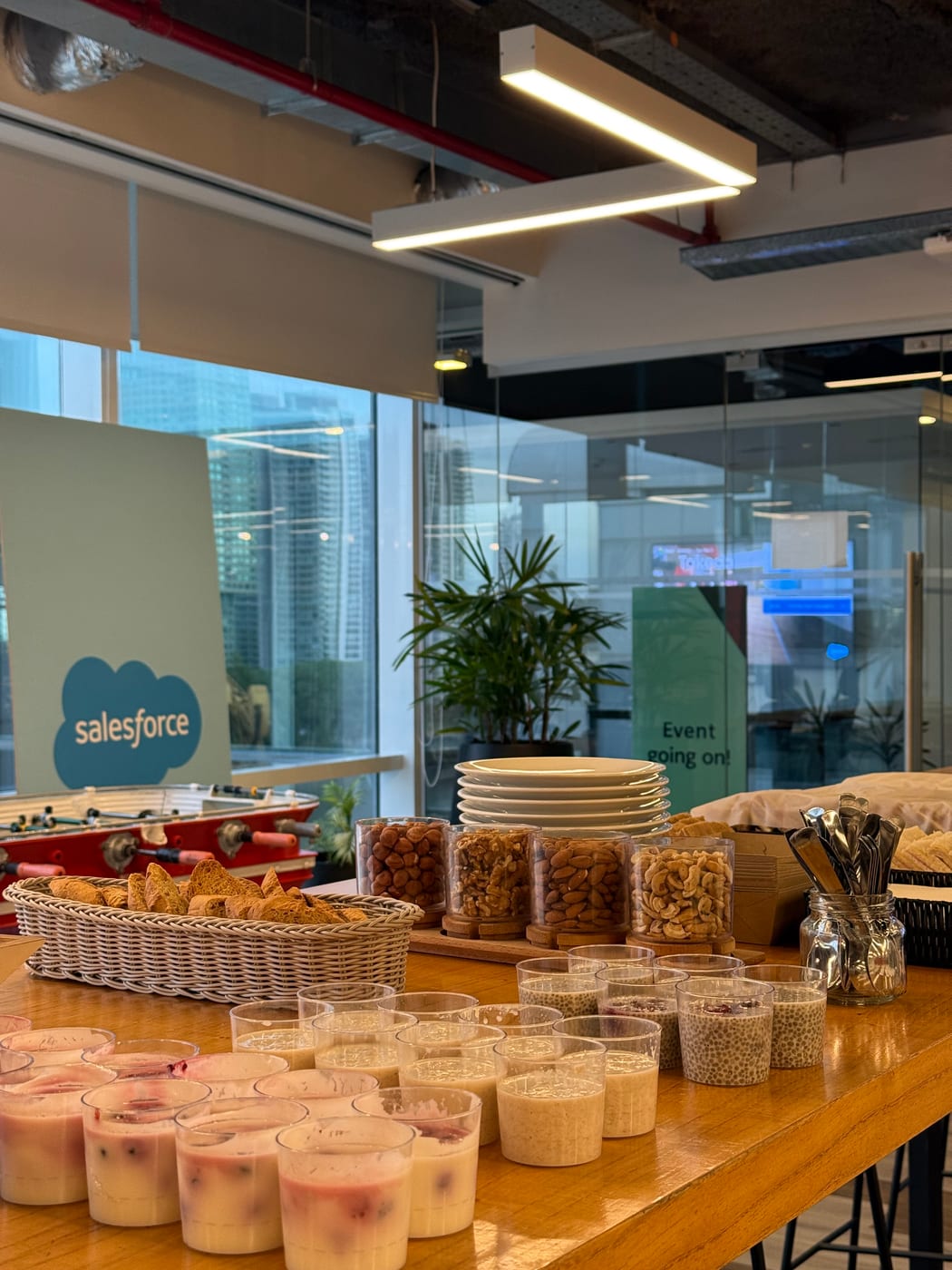 Detalle de frutos secos, granola y vasitos de yogur en una mesa de desayuno corporativo