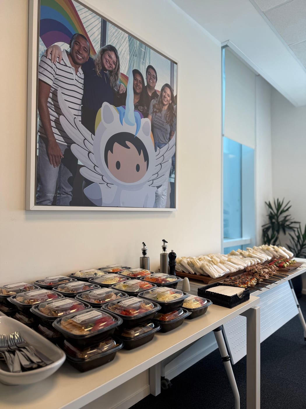 Buffet de almuerzo corporativo con viandas individuales, wraps y brochettes en una oficina