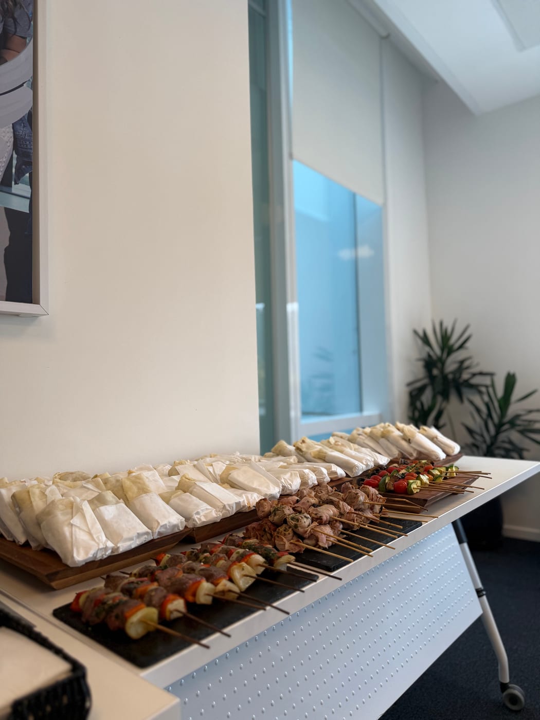 Recepción con wraps envueltos y brochettes de carne y vegetales sobre tablas de madera
