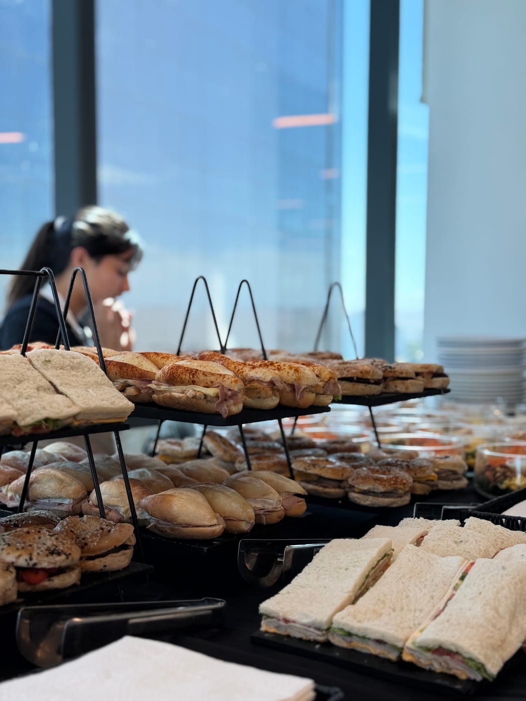 Estacion de sandwiches variados en gradas metalicas para almuerzo de oficina