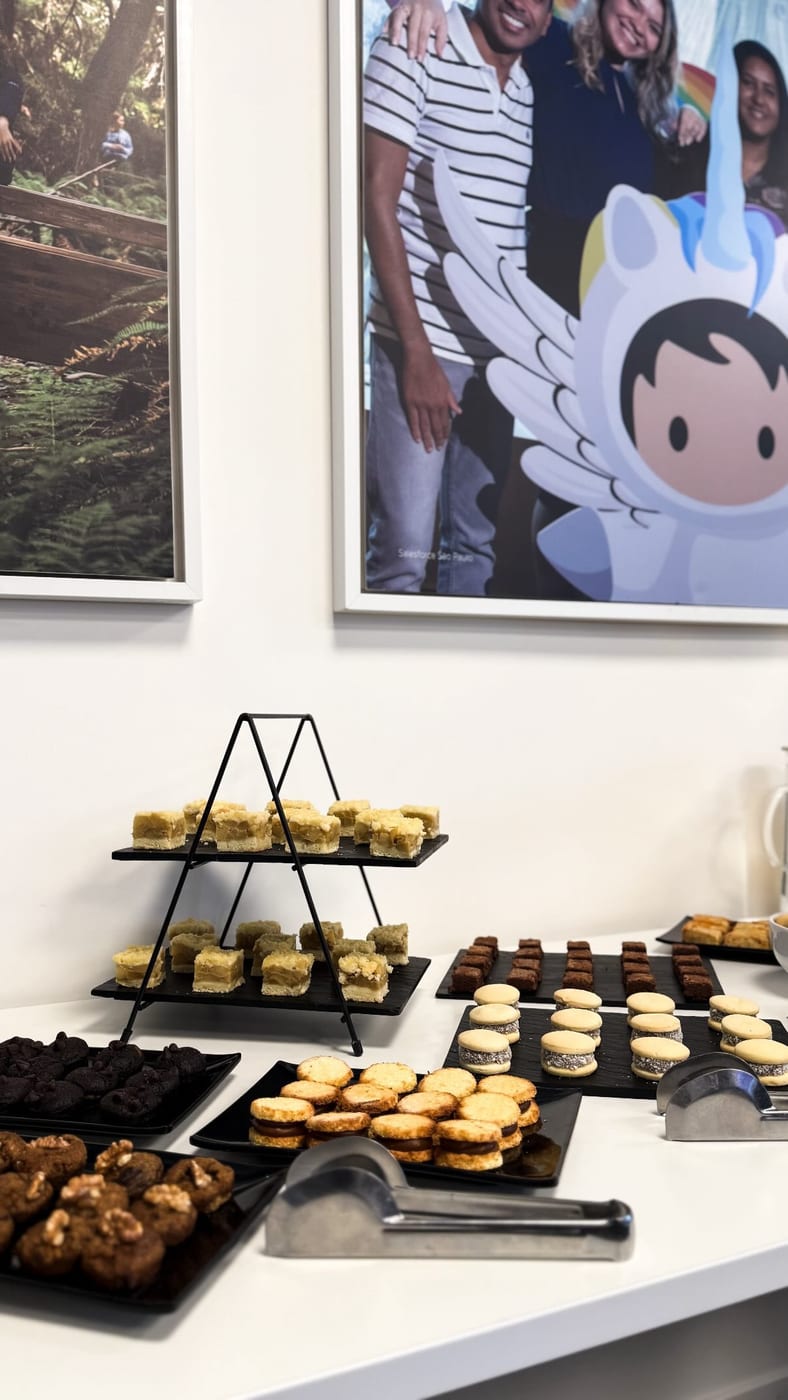 Estacion de coffee break con torre de lemon pie, brownies, alfajores de maicena y pepas surtidas en bandejas negras