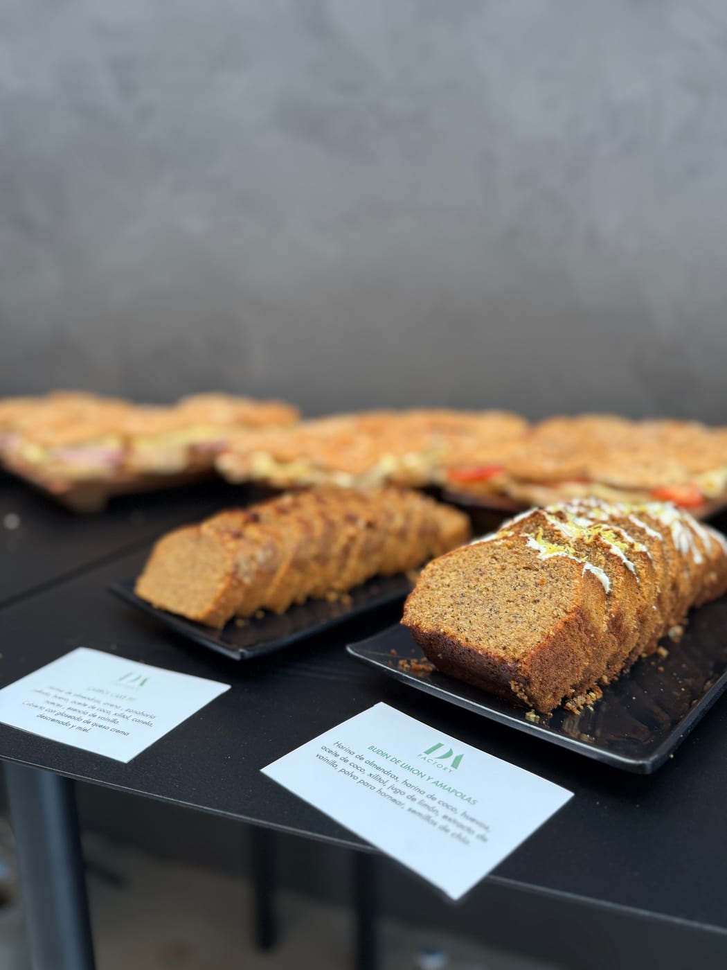 Budines caseros en rodajas -carrot cake y budin de limon y amapolas- presentados en bandejas para un coffee break de DA Catering