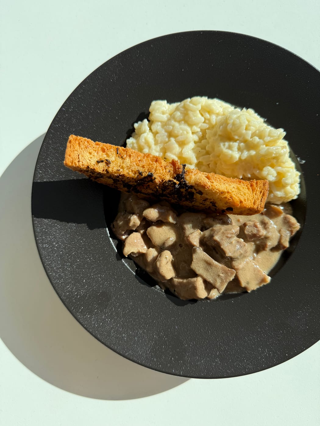 Plato de carne al champiñón con salsa cremosa, arroz y tostada para un almuerzo corporativo